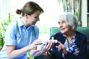 Nurse Advising Senior Woman On Medication At Home